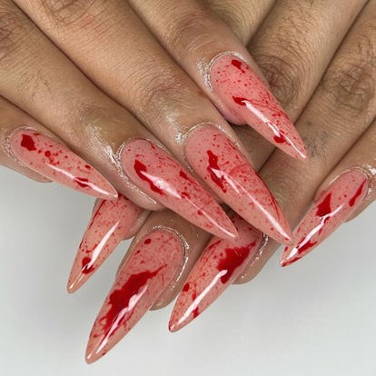 Bloody stiletto nails are a spooky yet cute Halloween nail design for 2023.